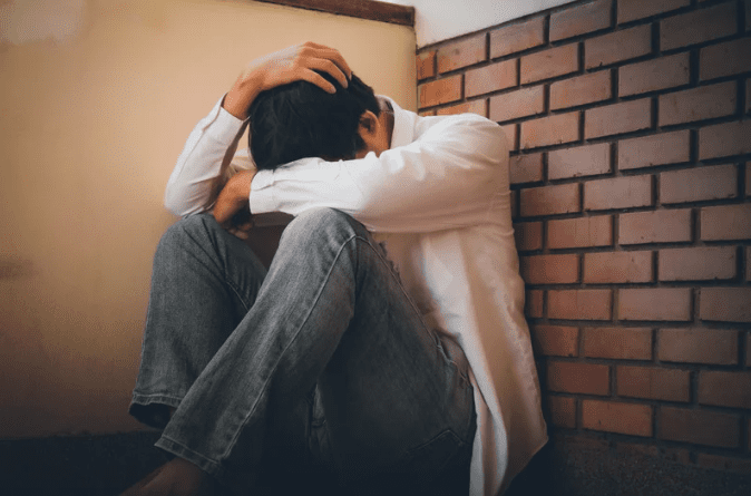 Depressed young man hiding his face