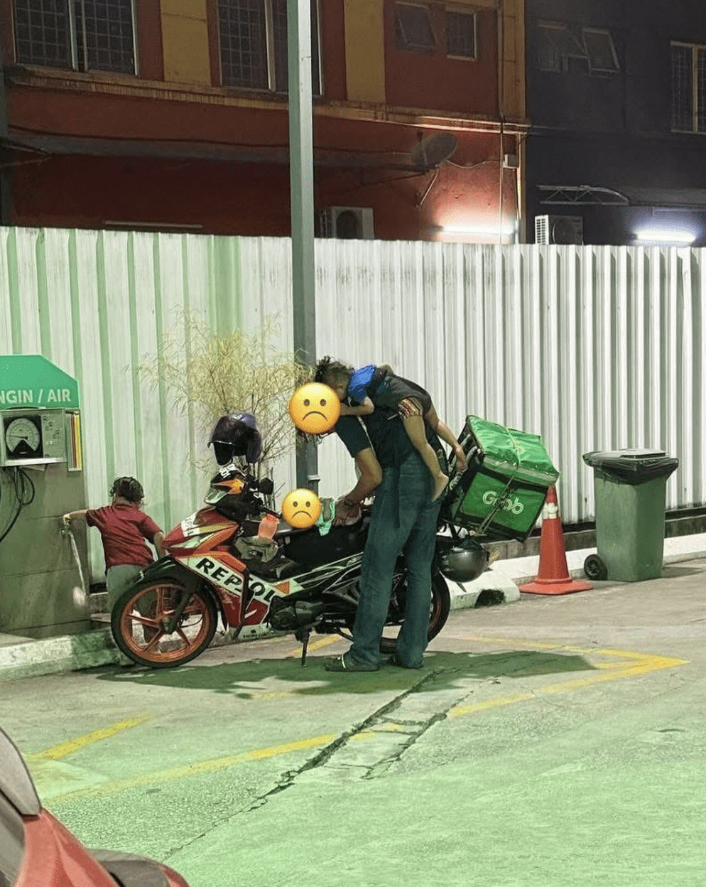 Father of 3 changing diaper at petrol station
