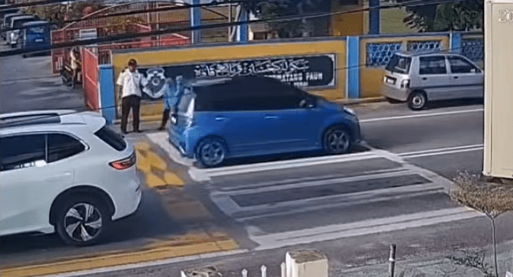 Female students waiting to cross the road in Penang