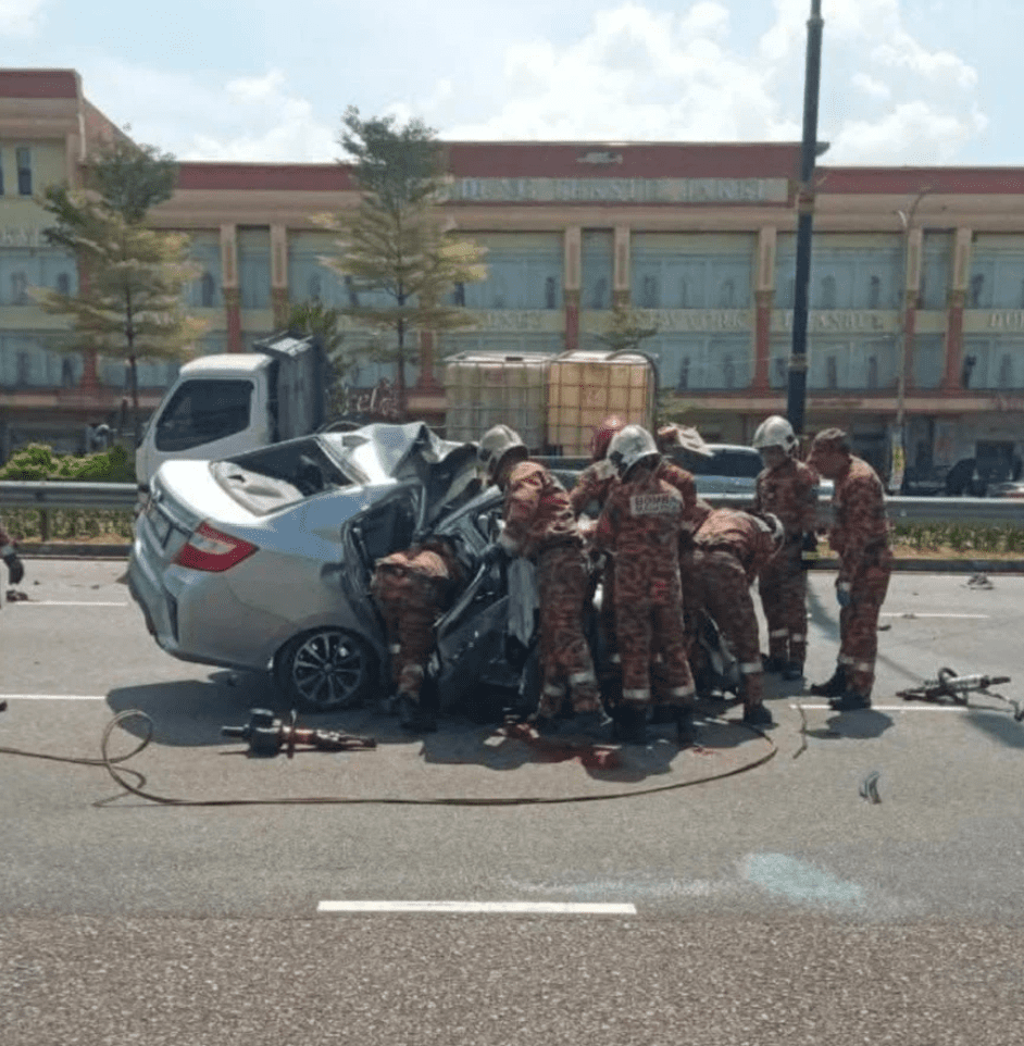 Firefighters inspecting wrecked car in JB crash