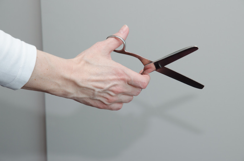 hand holding scissors