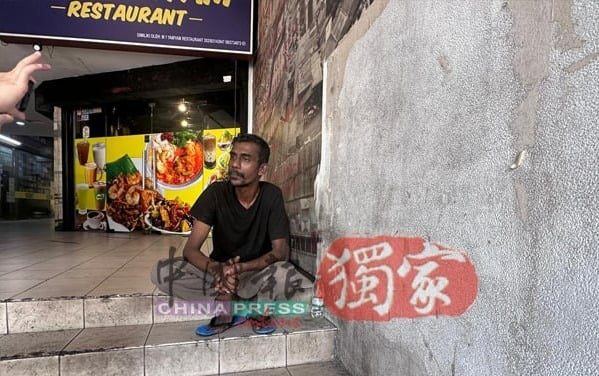 Homeless man sitting outside Menara Landmark