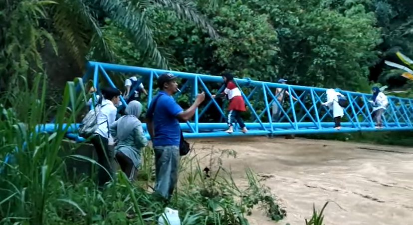 Keningau students precariously cross a river by using pipeline
