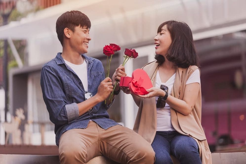 Man gives flowers and gifts to his girlfriend on Valentine's Day