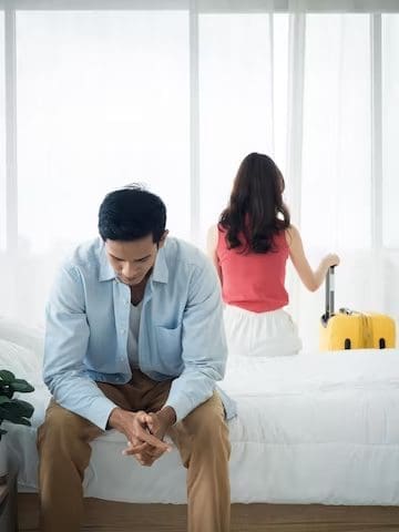 Depressed husband with wife holding a luggage
