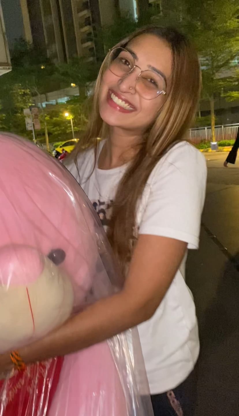 woman holding a pink teddy bear