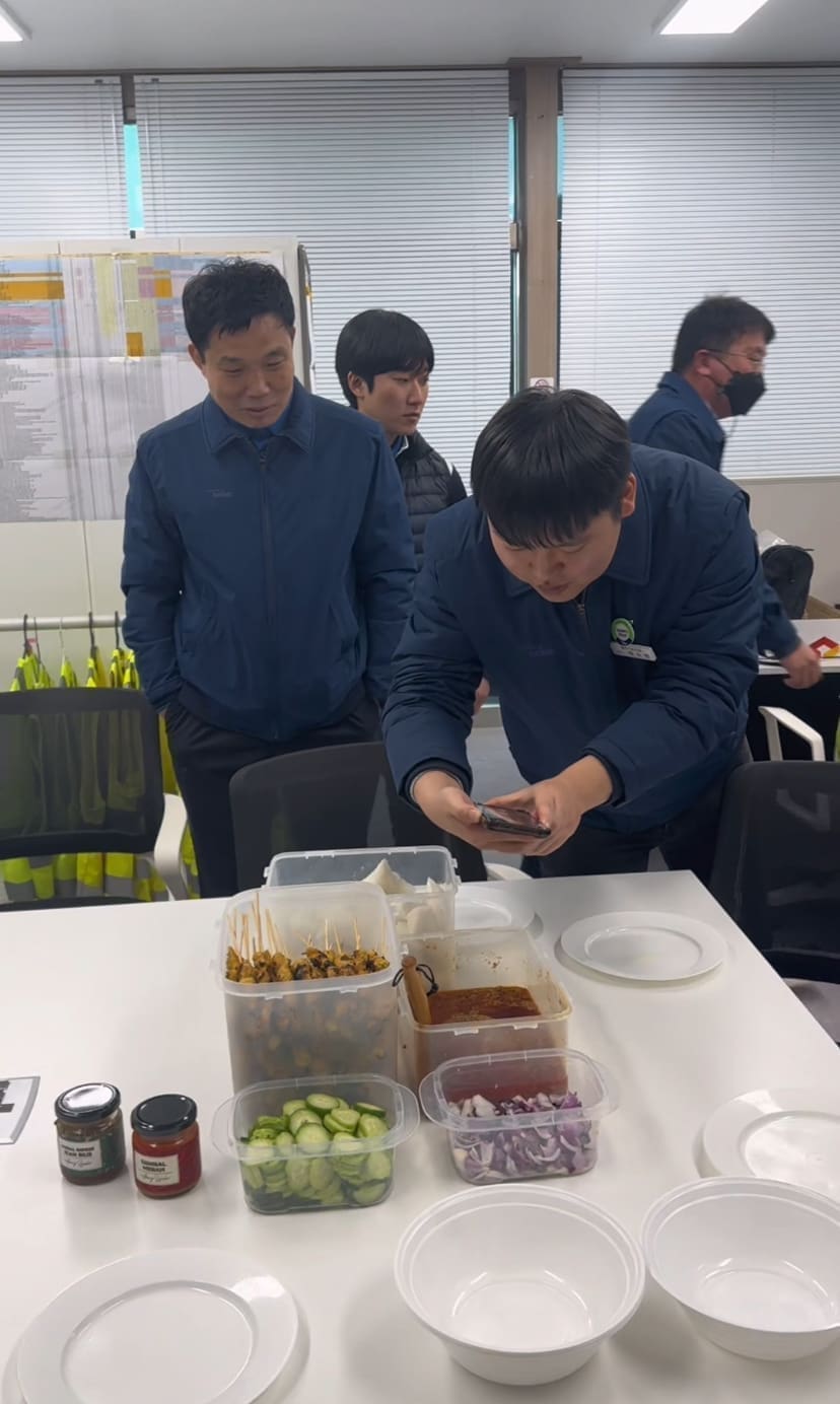korean man taking pic of satay
