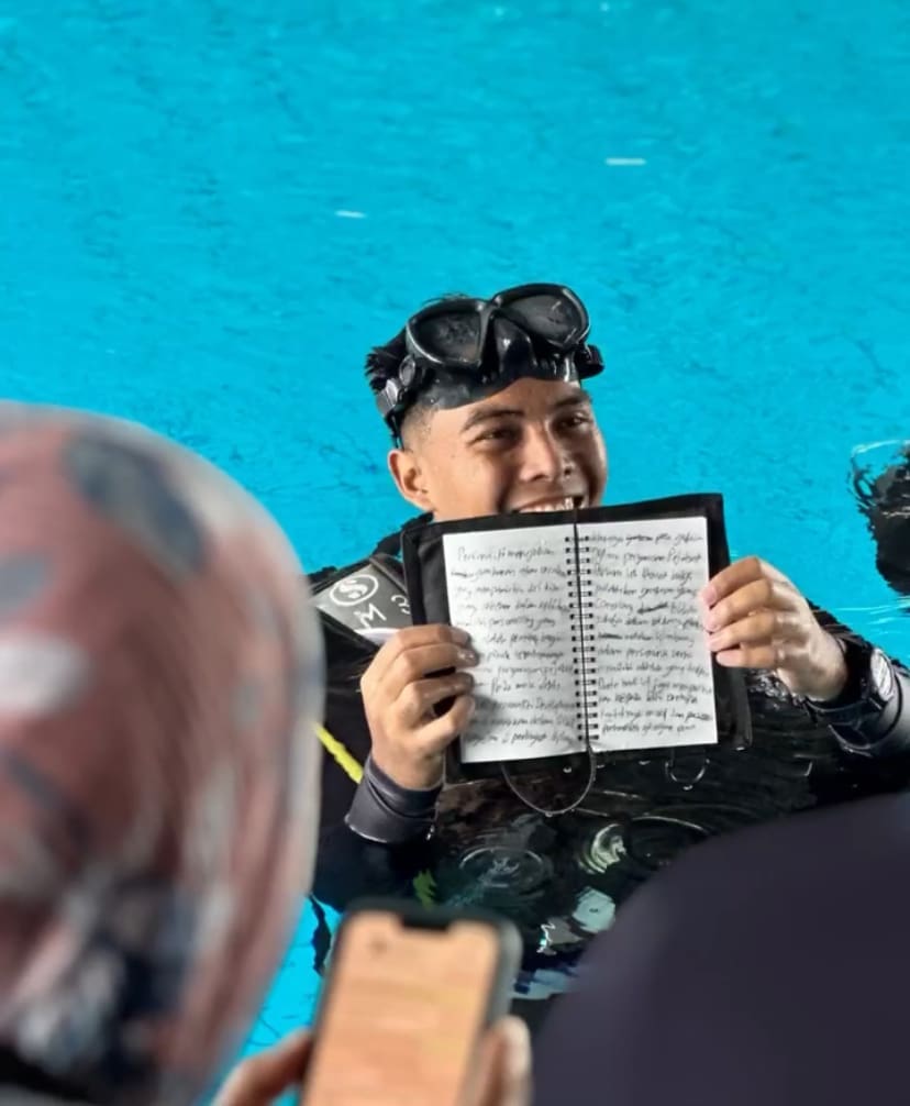Ahmad Fudhail Ahmad Kenedi showing the essay he wrote while underwater