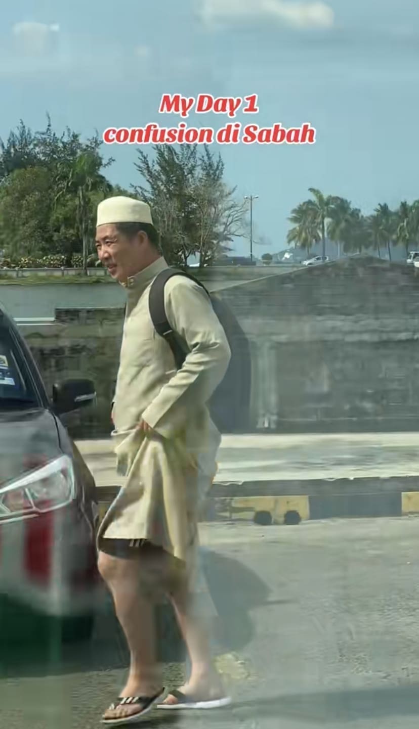 Tourist in white 'jubah' coming back from visiting Masjid at Sabah