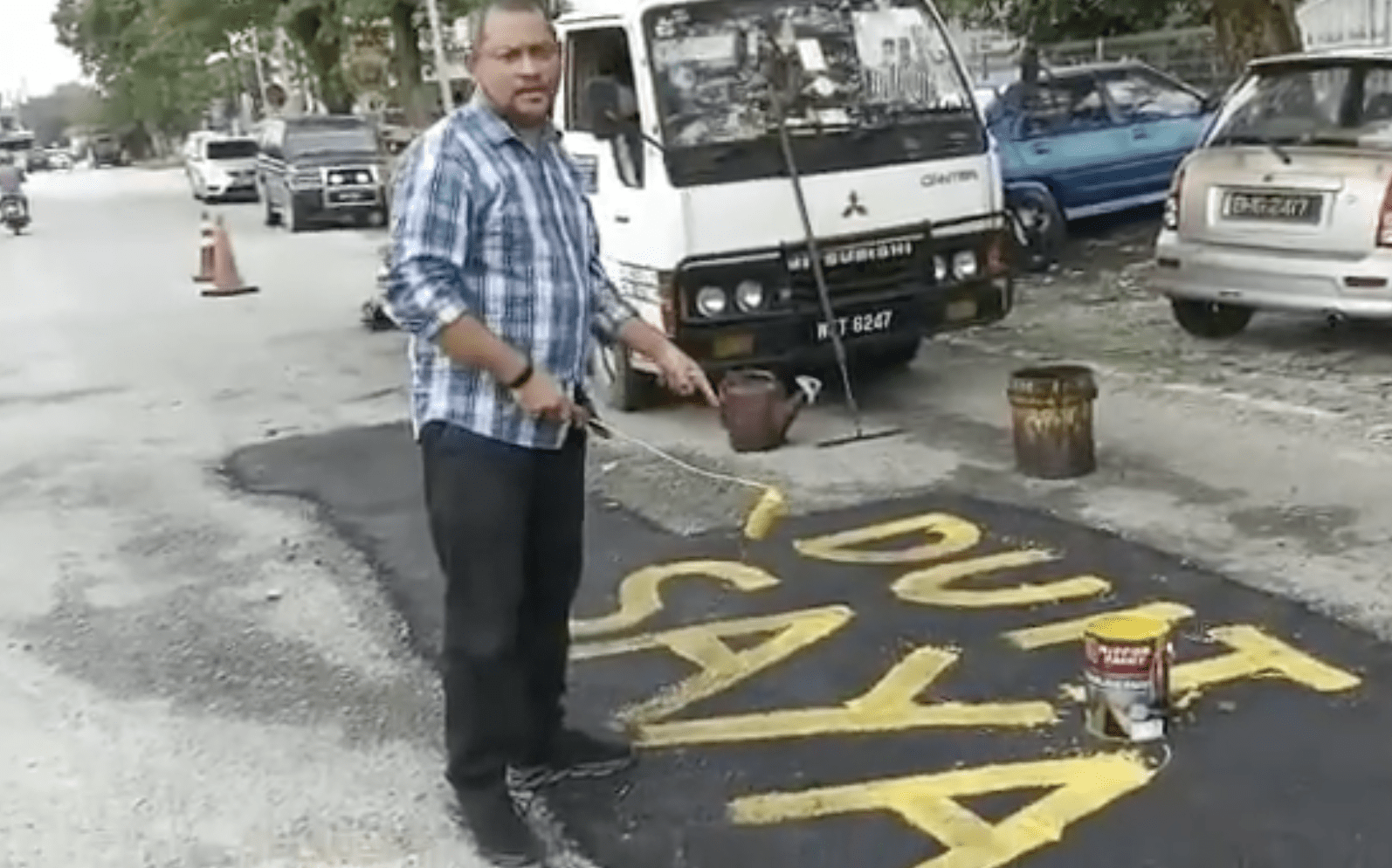 Klang Man Writes 'My Money' on potholes he fixed 01