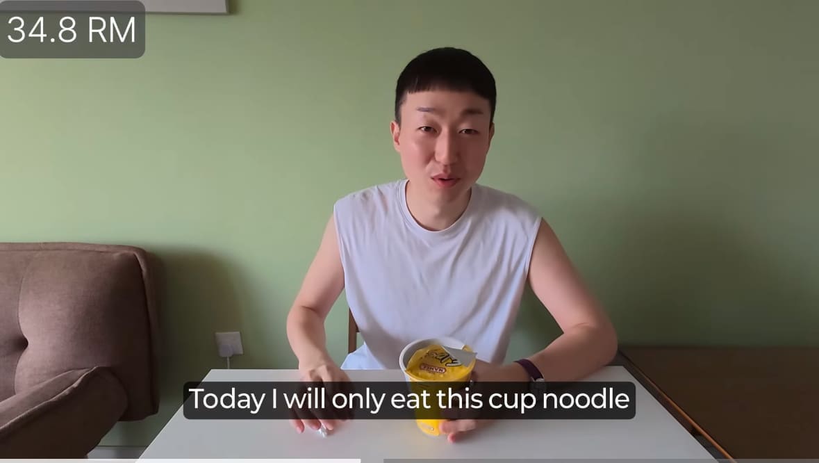 korean man eats cup noodles