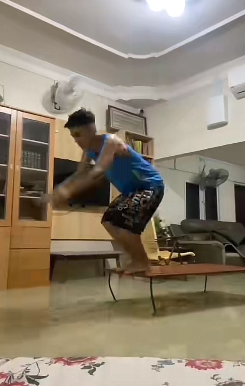 man dives in to the water flooded in his house