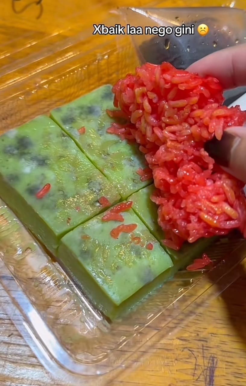 M'sian Woman lifting the sticky rice to show the fungus on the kuih