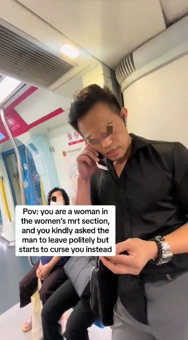 M'sian man talking on the phone at women's coach 