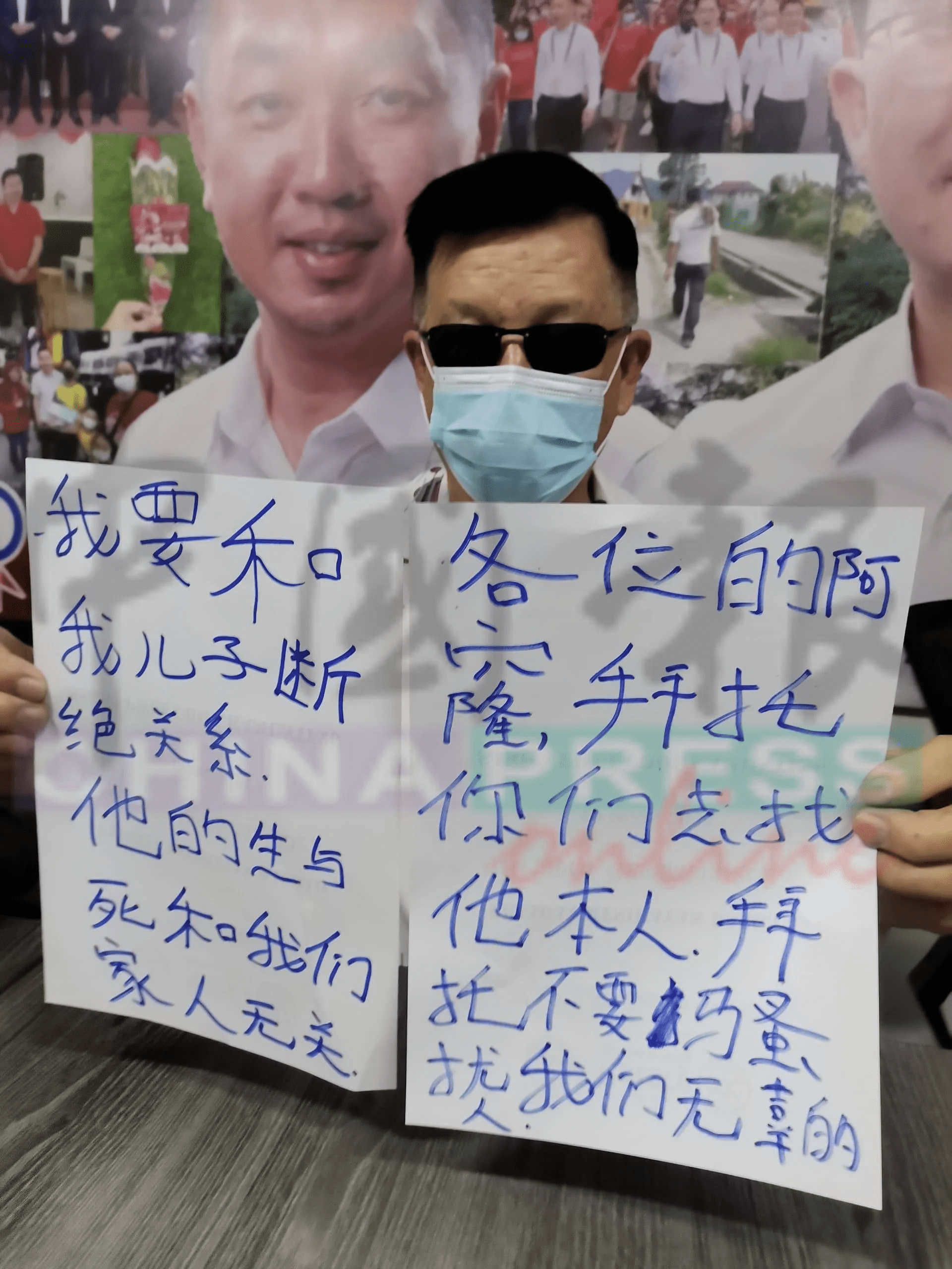 Ma holds sign which announced son's disownment
