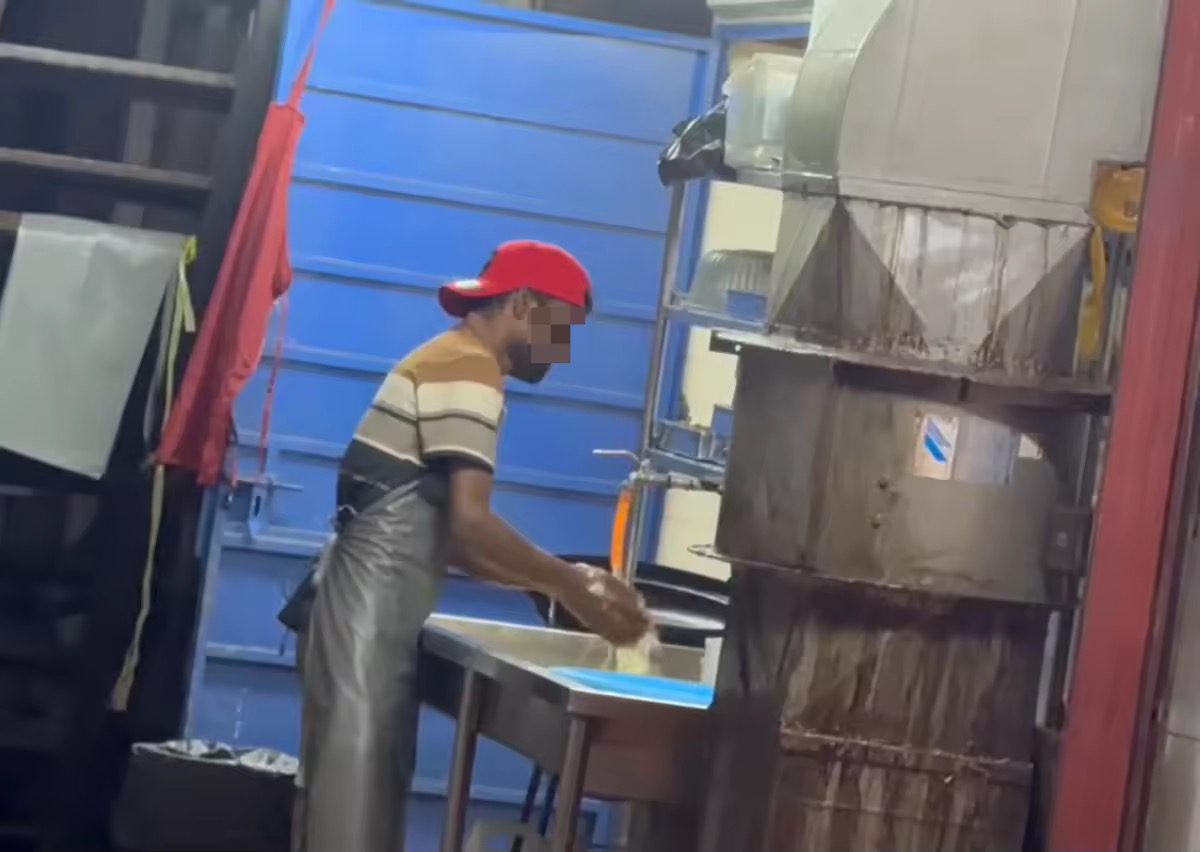 Mamak worker washes leftover food (1)