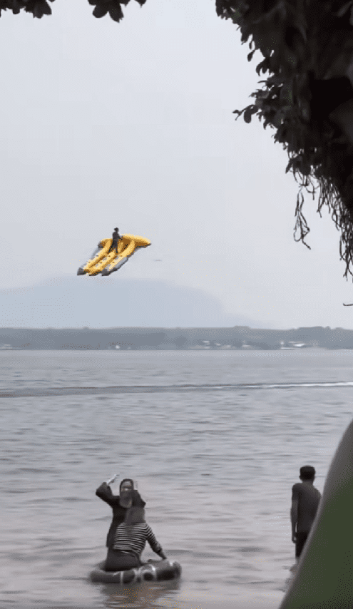 man flying on top of triple inflatable banana boat