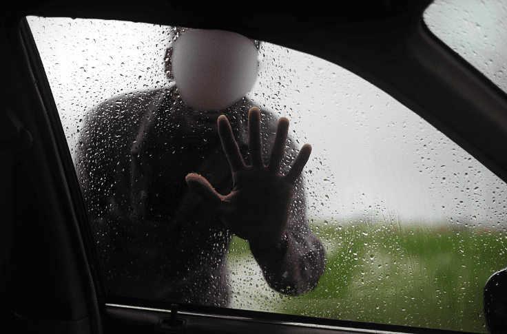 Man placing hand on car window
