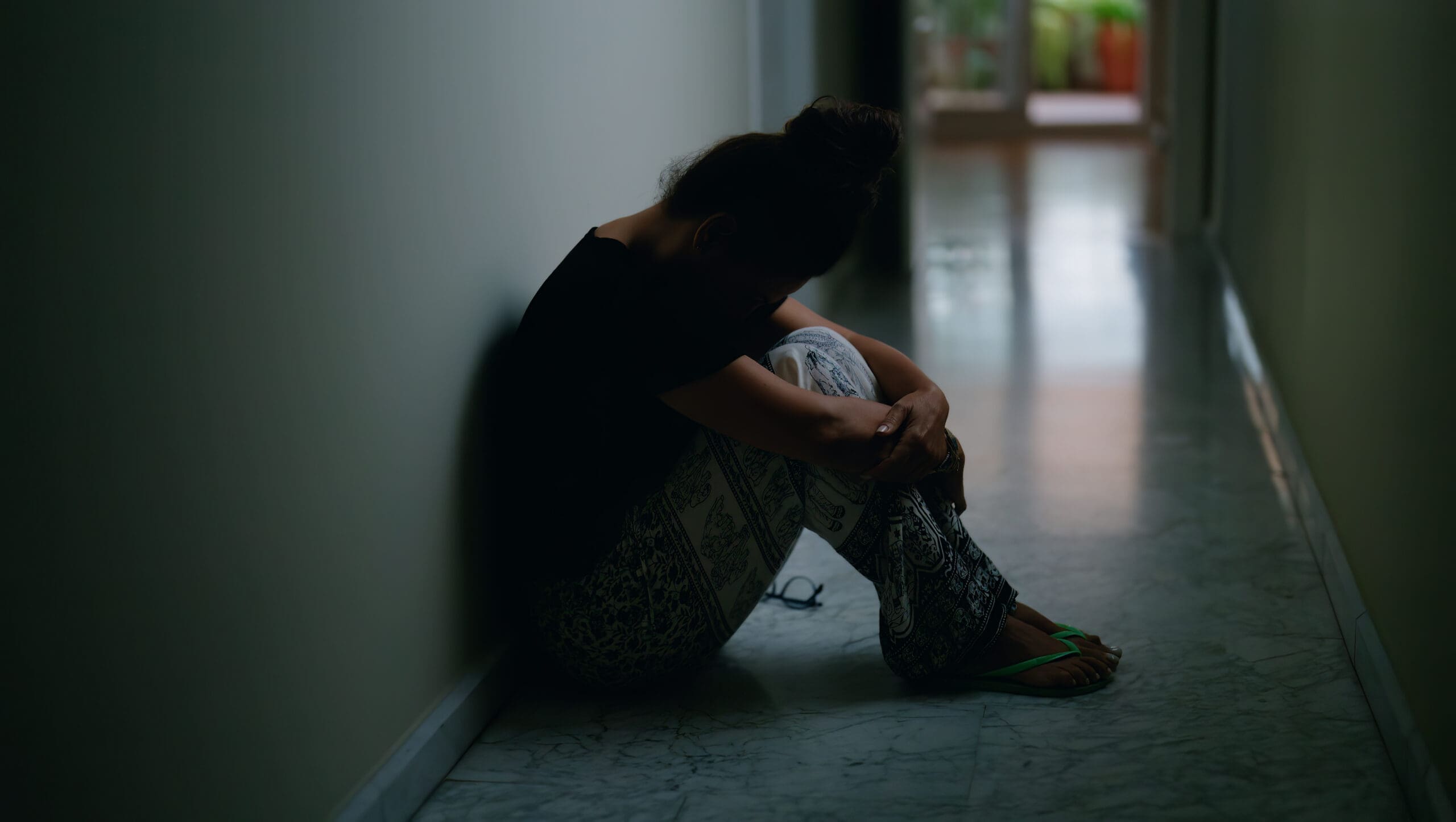 sad woman sitting at a corridor