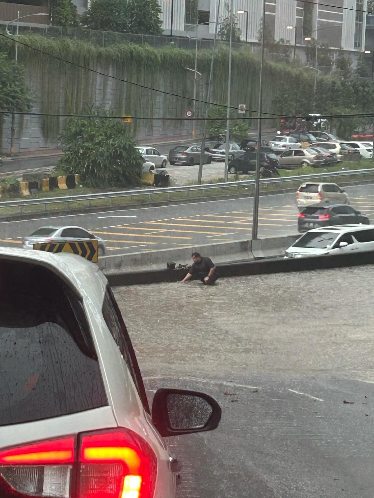 Motorcyclist clearing clogged drain