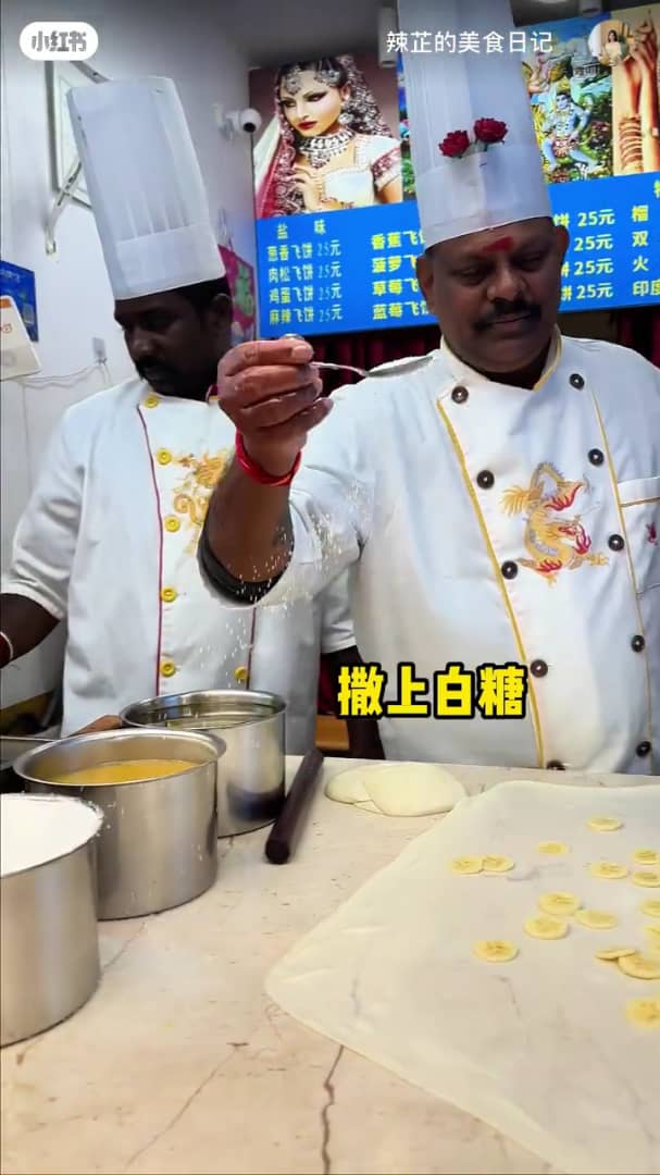 msian cook putting sugar on roti canai