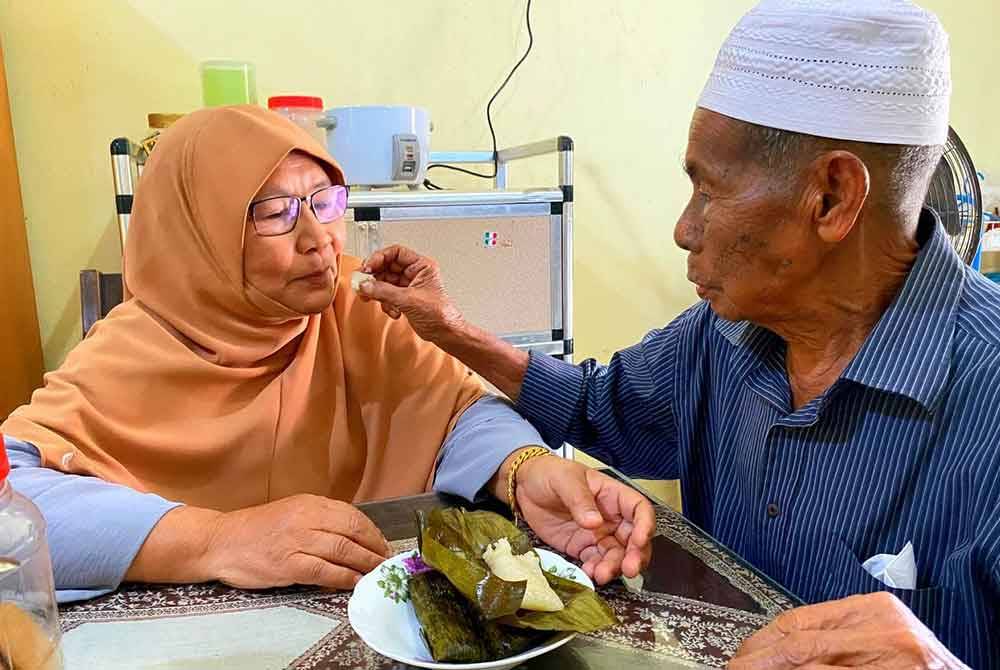msian man feeding food to his wife