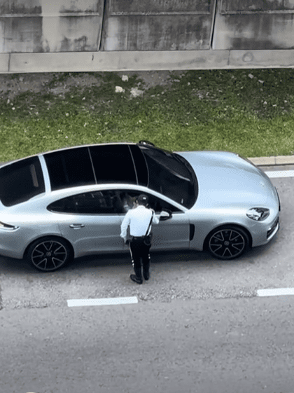 M'sian police officer talks to luxury car driver
