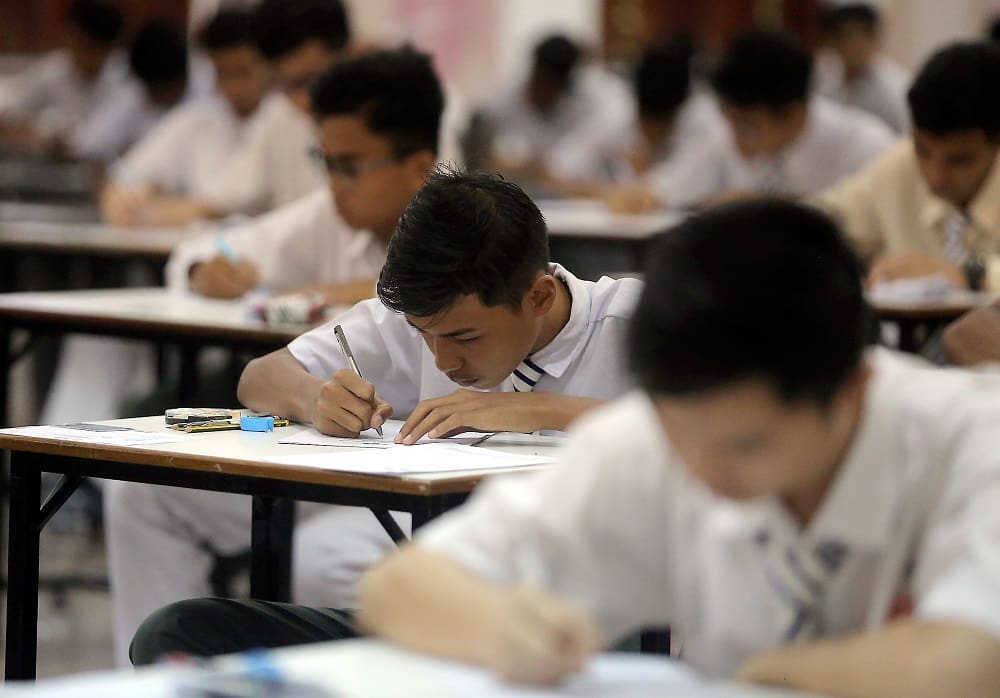 M'sian student writing on exam paper