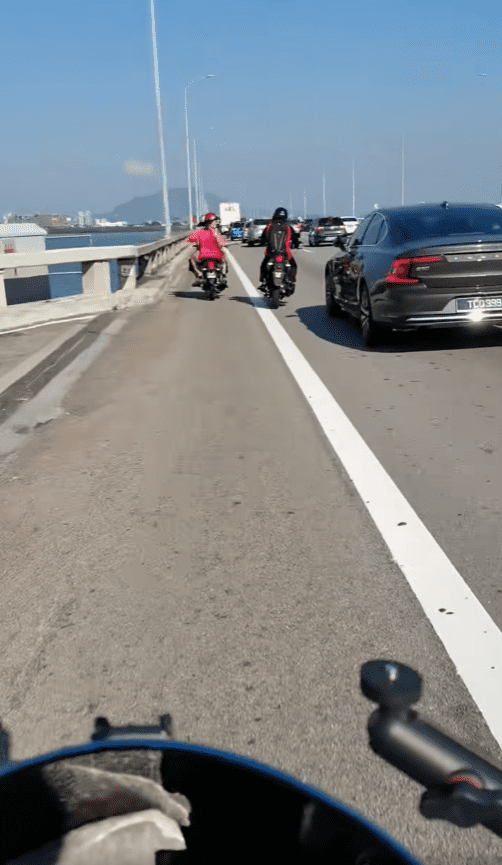 msian woman throwing sand at other motor rider