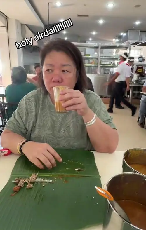 msian woman drinking dhal in the cup
