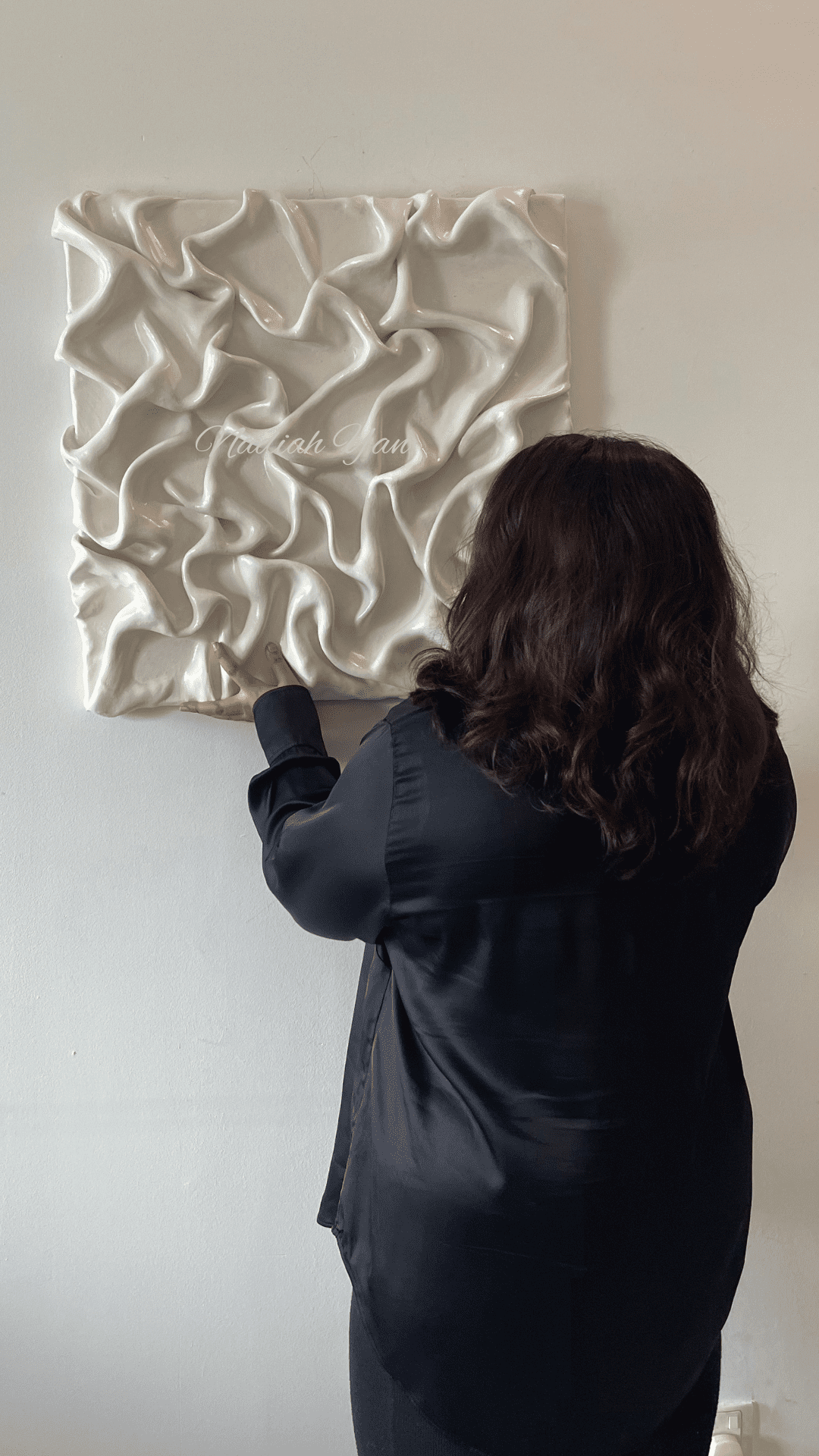 Nadiah Yan, looking at her abstract painting
