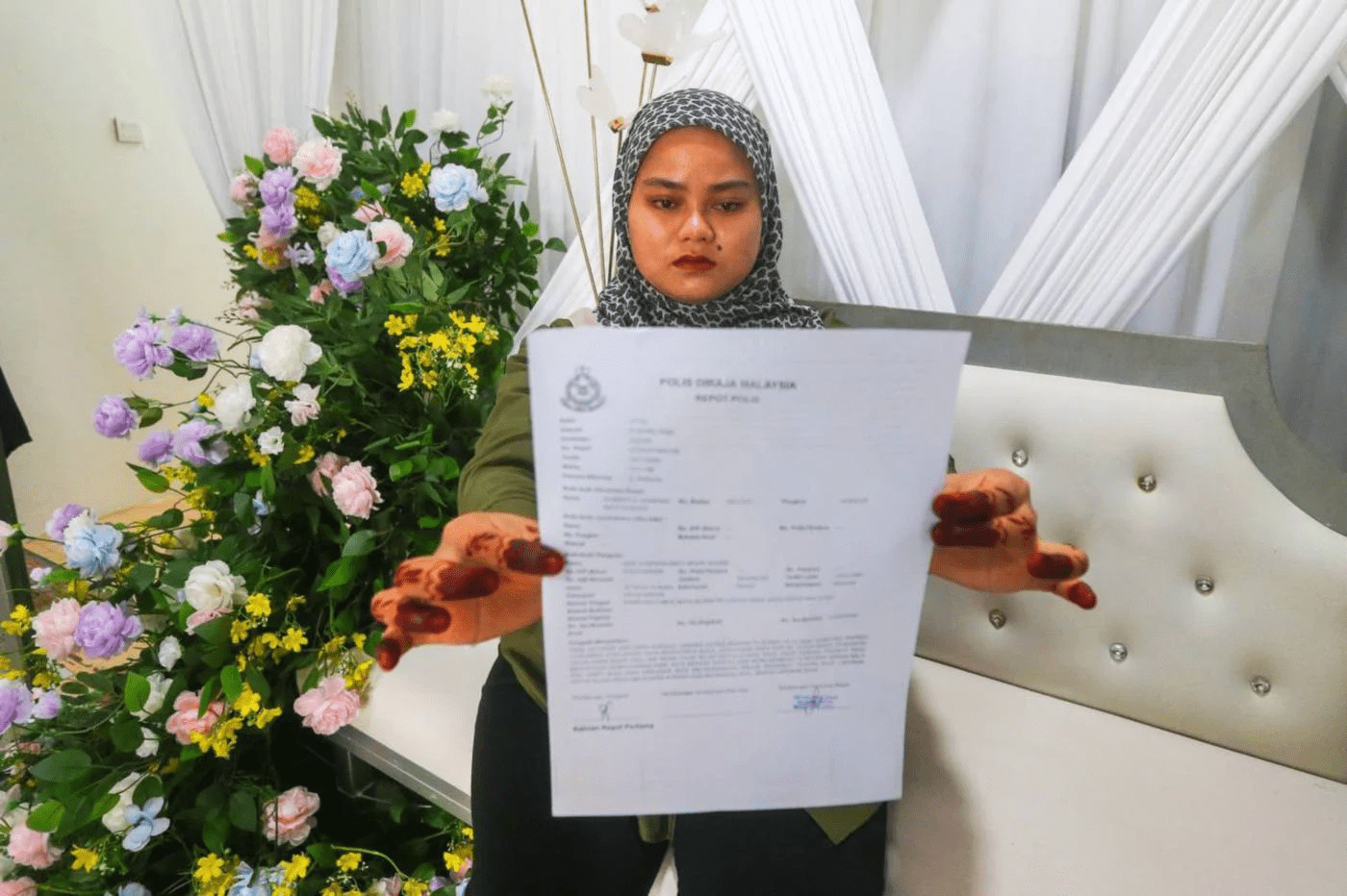 Nor Syafiqah holding police report