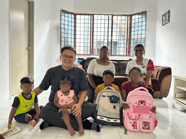 Ong Chun Wei posing with single mum's family