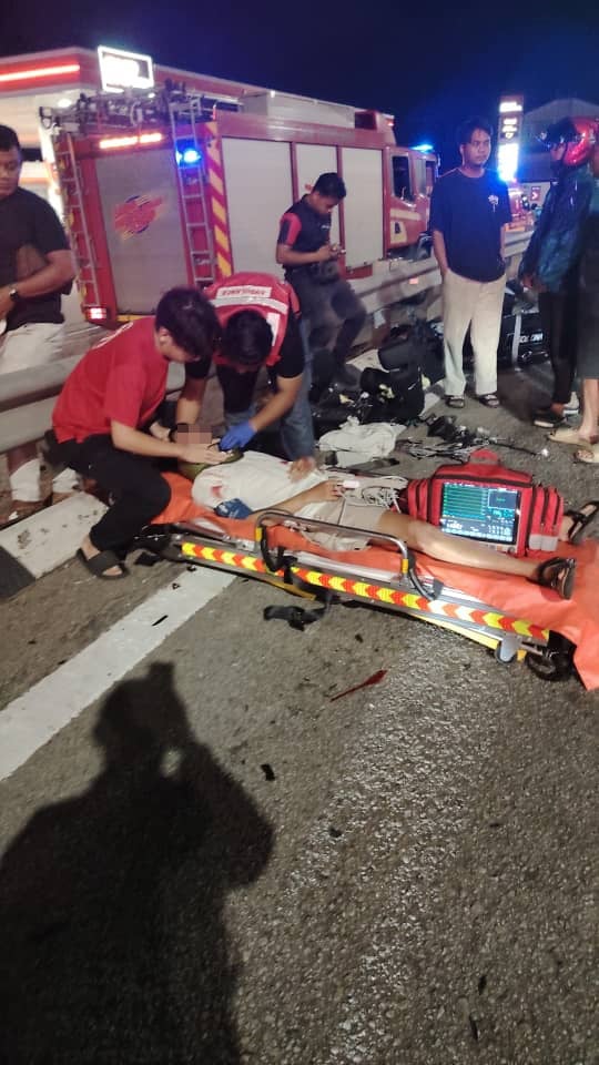 Paramedics tending to injured man in road divider accident in Puchong