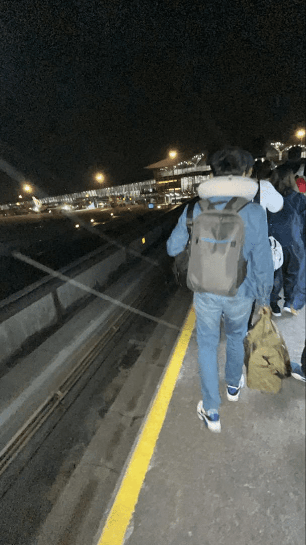 Passengers walk along Aerotrain tracks 1