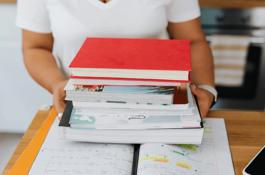 person holding school textbooks