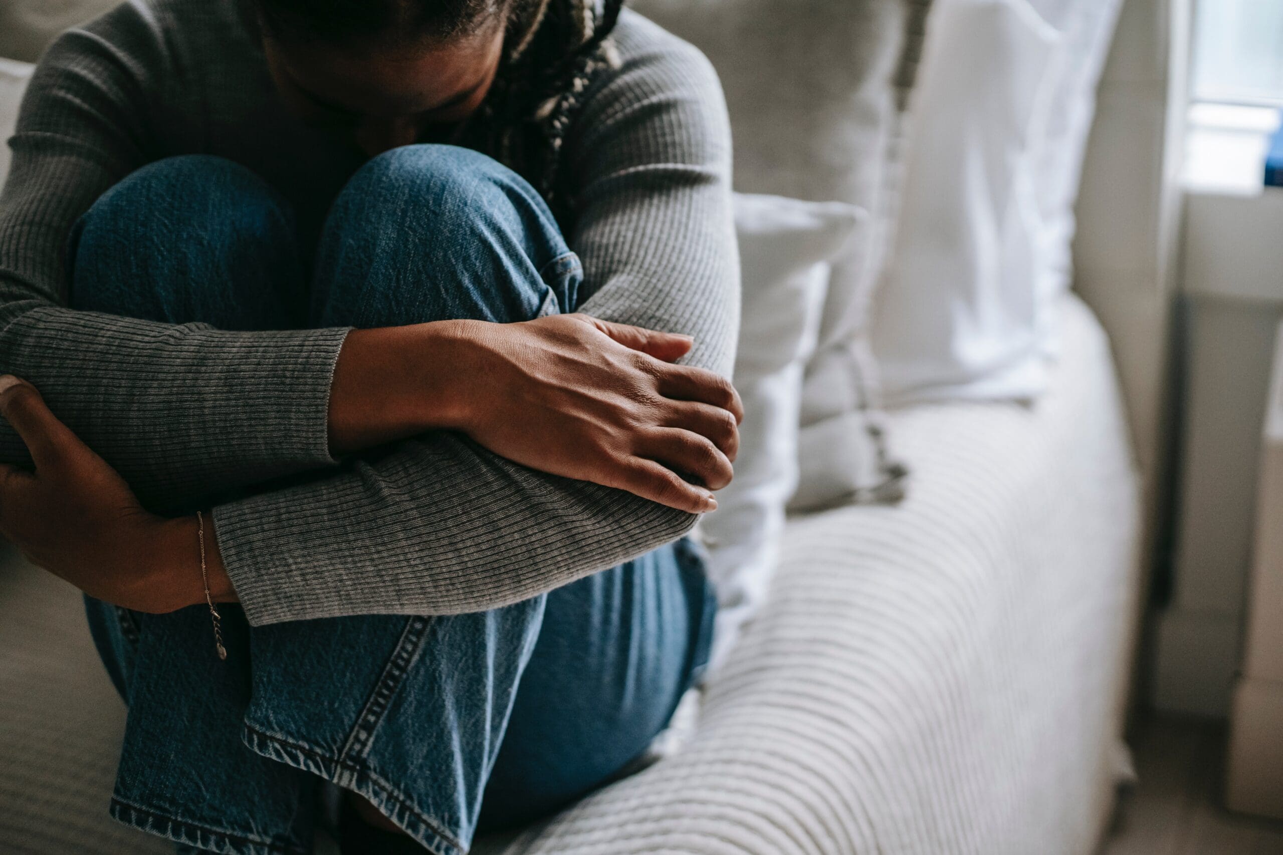 woman covering her face with her knees
