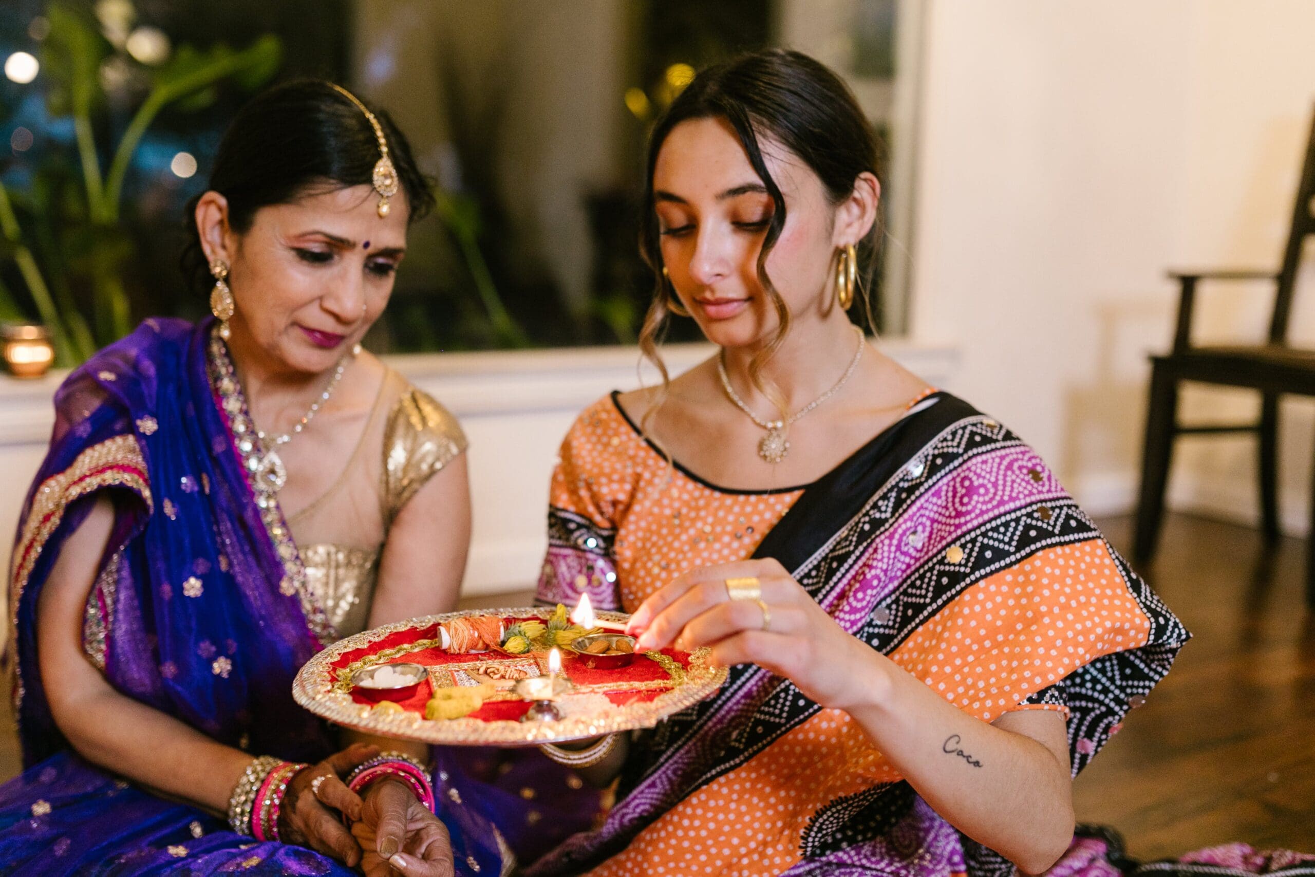 2 Indian girls lighting oil lamp