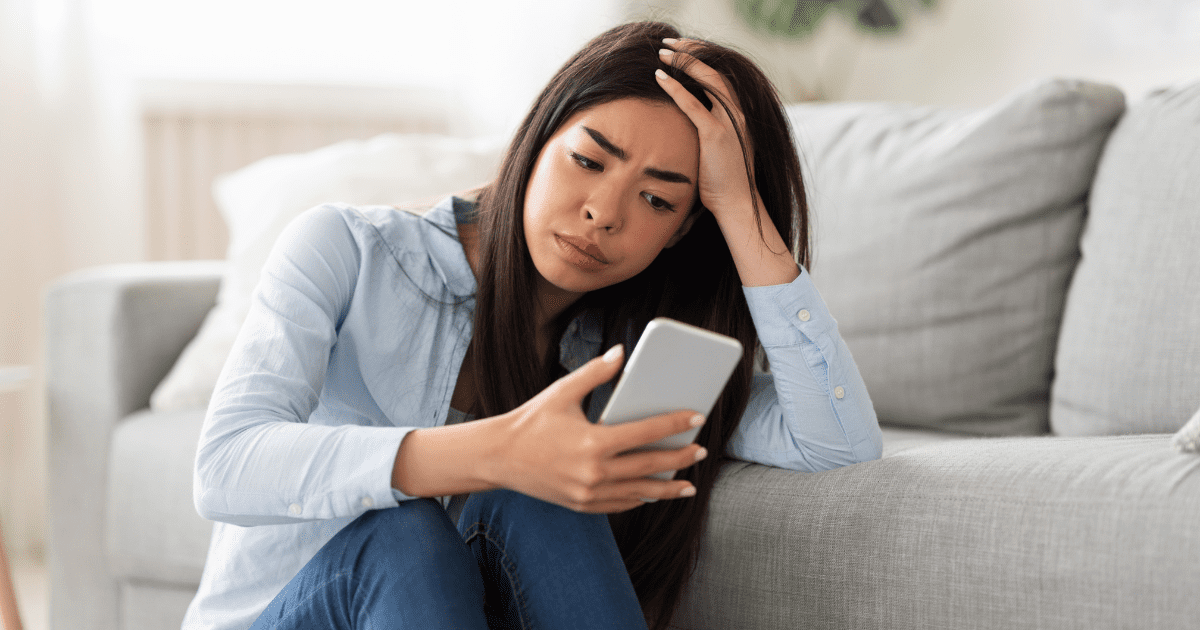 sad woman looking at her phone