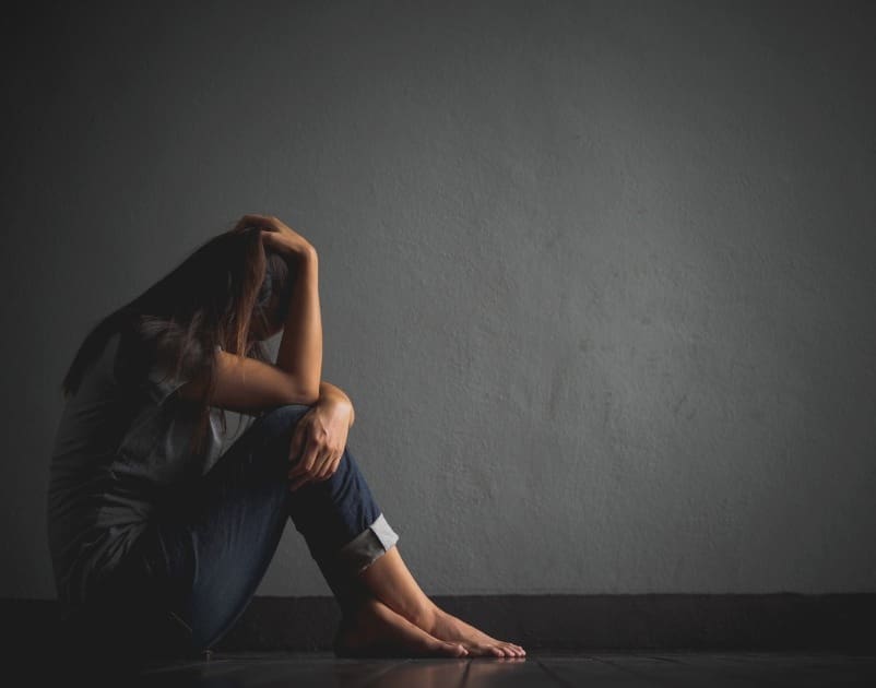sad woman sitting alone in a dark room