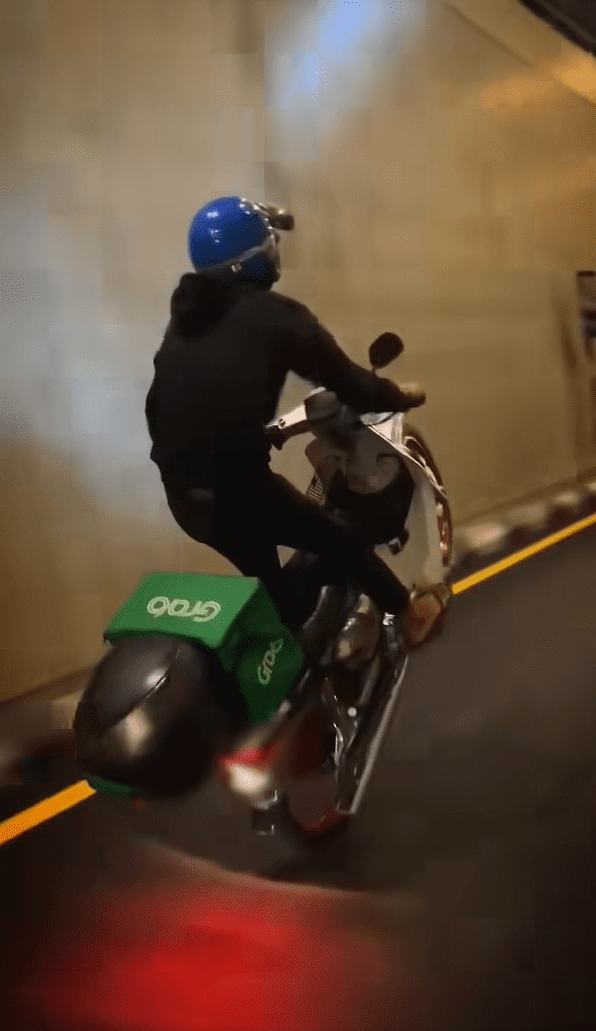 delivery rider doing wheelie stunt with his motorbike