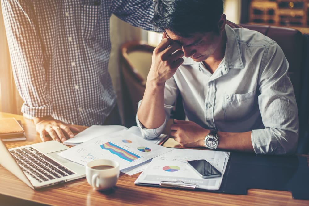 Man stressed out at workplace consoled by another person