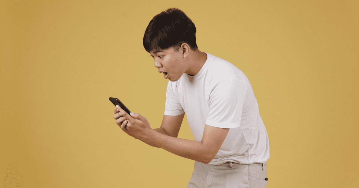 shock asian man looking at the phone