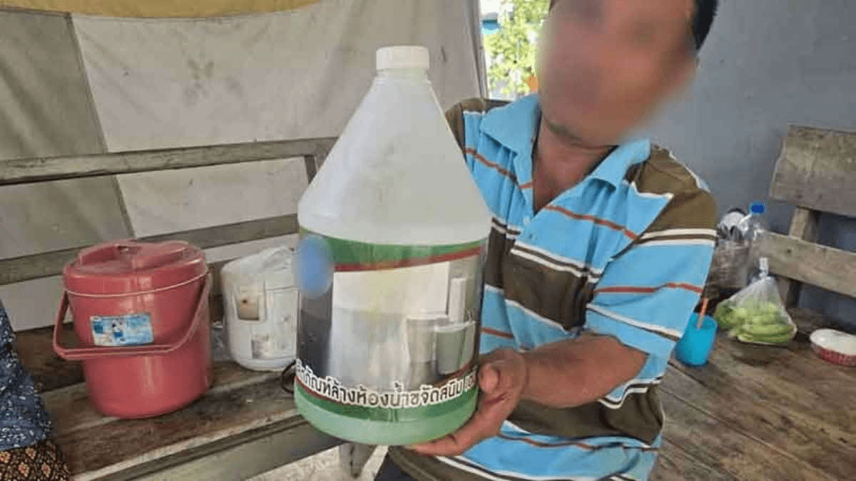 Thai man holding bottle of toilet cleaner
