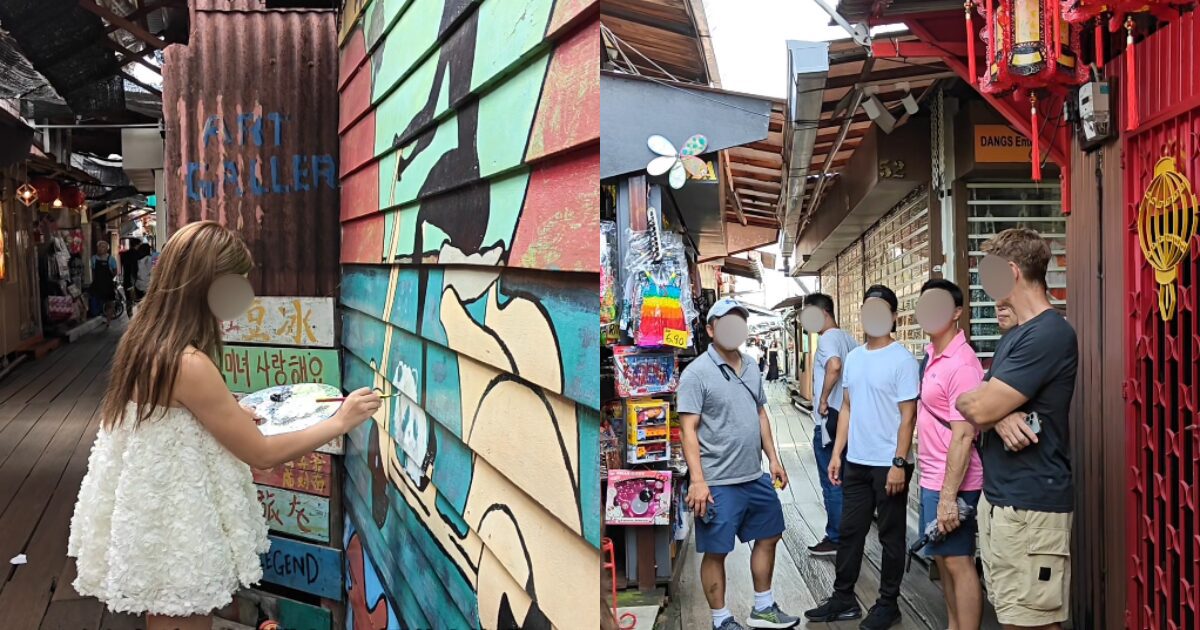 Tourists looking at woman painting a panda at Chew Jetty