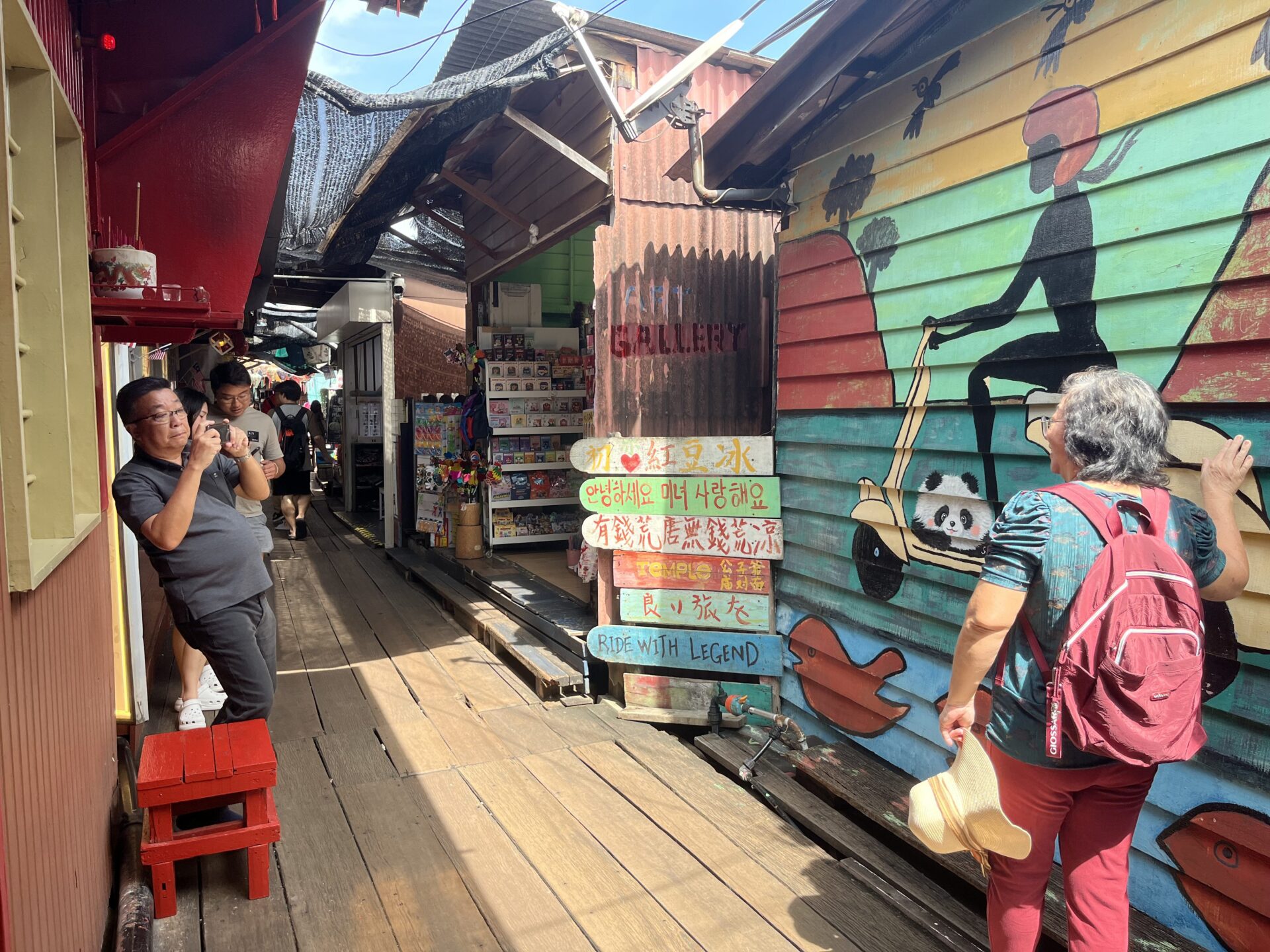 Tourists posing at panda mural at Chew Jetty