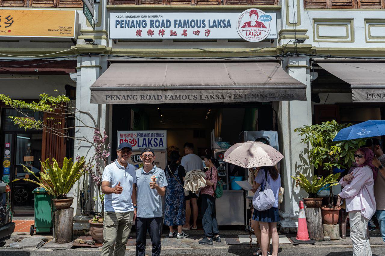 Tourists posing outside laksa restaurant in Penang
