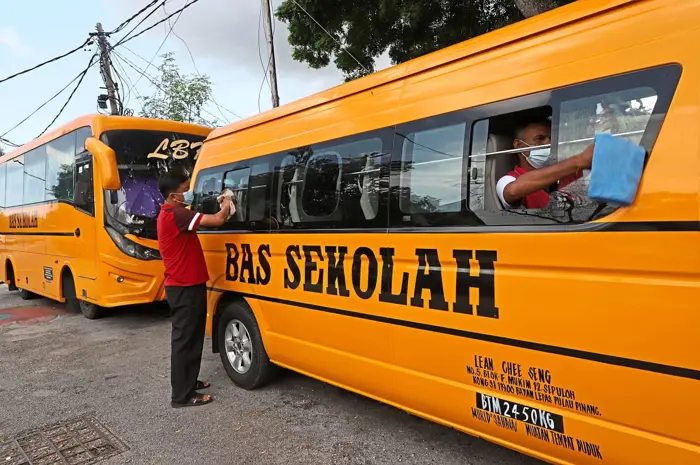 two men cleaning their school vans
