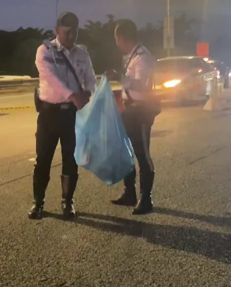 two policemen holding rubbish bag