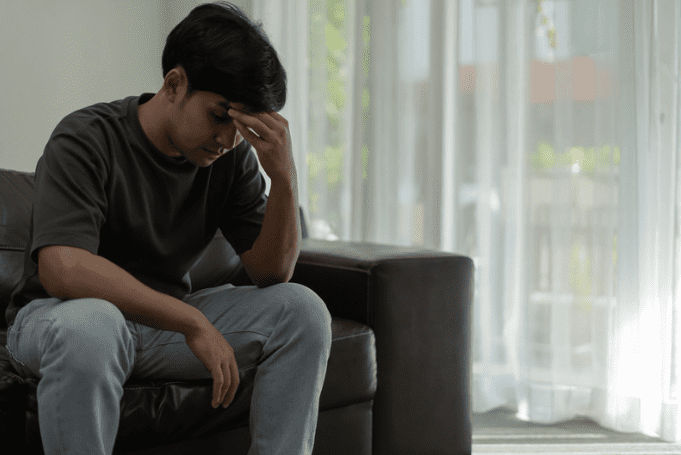 Upset Asian man on the sofa